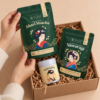 The Mitsu Matcha Collection unboxing, hands lifting Akari matcha pouch from kraft gift box with Yawaragi and Satsuma